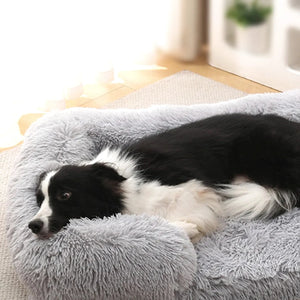 Border Collie relaxé sur un coussin anti stress chien gris rectangulaire en fausse fourrure douce
